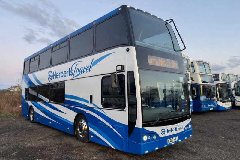A Herberts Travel double-decker in cobalt and white livery with the rest of the fleet behind it